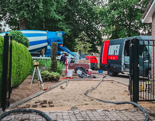 Betonpomp aanhanger en betonmixer bij het storten van een garagevloer