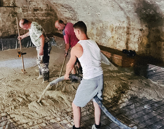 Vloer storten in een kelder met de betonpompslang
